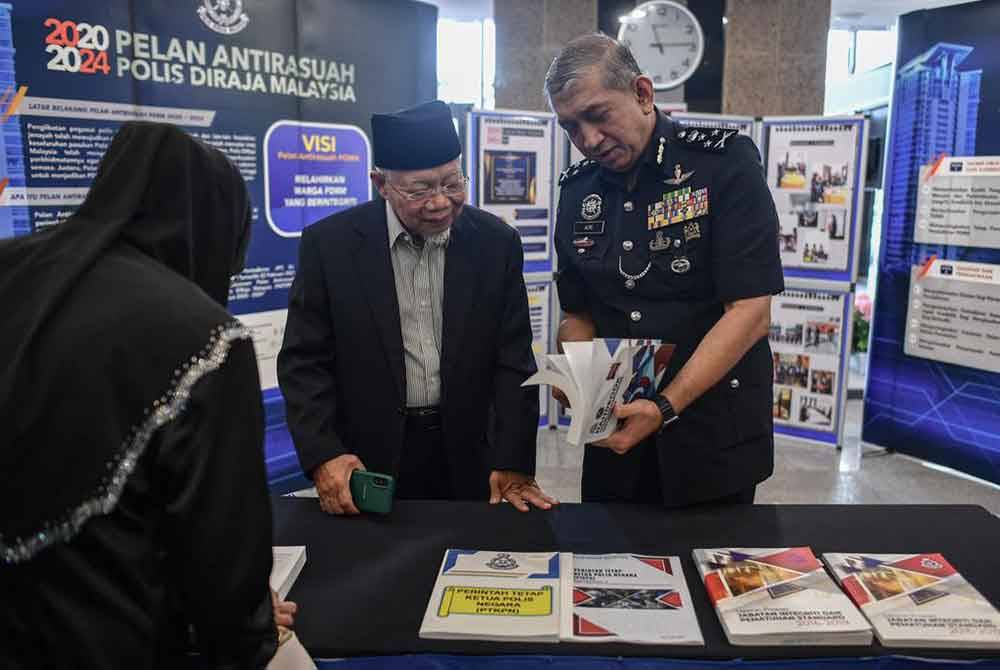 Azri (kanan) melakukan lawatan di reruai di Sambutan Satu Dekad Penubuhan JIPS di Bukit Aman, Kuala Lumpur pada Khamis.