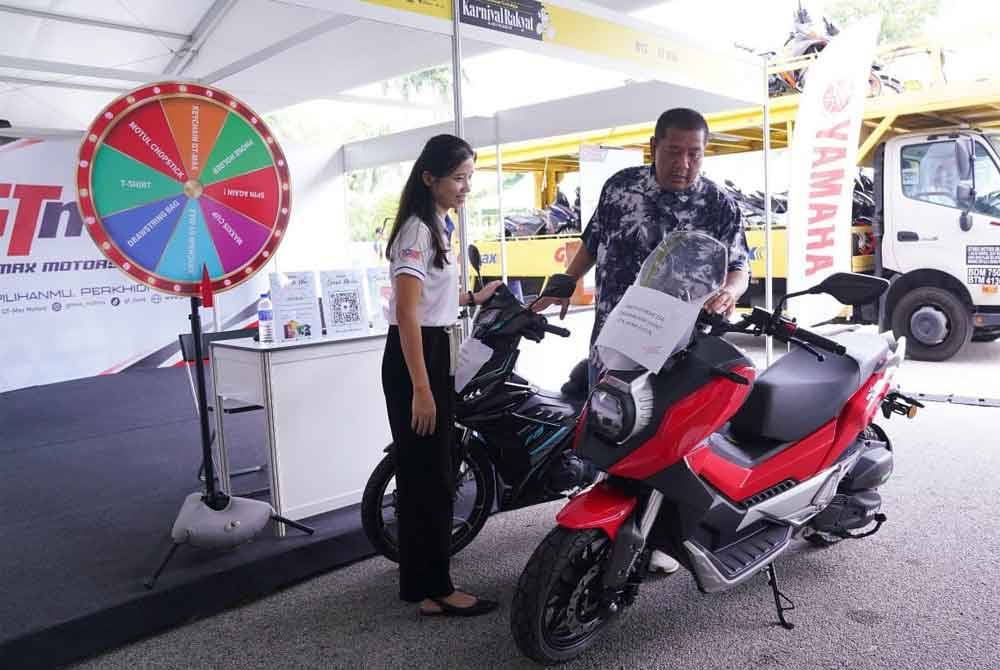 Ketua Pemasaran dan Penjenamaan Grup Sinar Karangkraf, Nik Justin Nik Mohd Ariffin (kanan) memeriksa hadiah cabutan bertuah yang bakal dimenangi pengunjung.