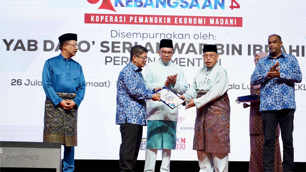 Abdul Fattah (dua dari kanan) memberikan resolusi yang dibentangkan kepada Ewon dalam Majlis Penutupan Kongres Koperasi Kebangsaan 2024.