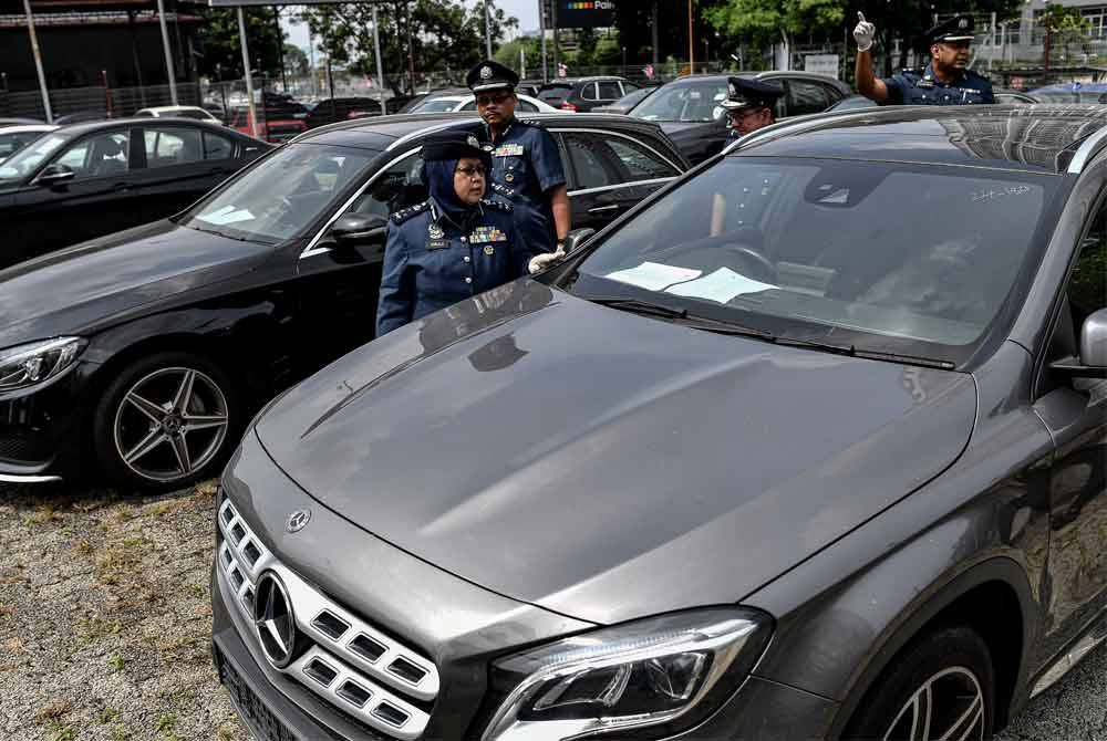 Norlela menunjukkan sebahagian 16 kenderaan import yang disyaki tak berkastam disimpan melebihi tempoh di dalam gudang ketika sidang media di Kompleks Kastam WPKL pada Jumaat. Foto Bernama