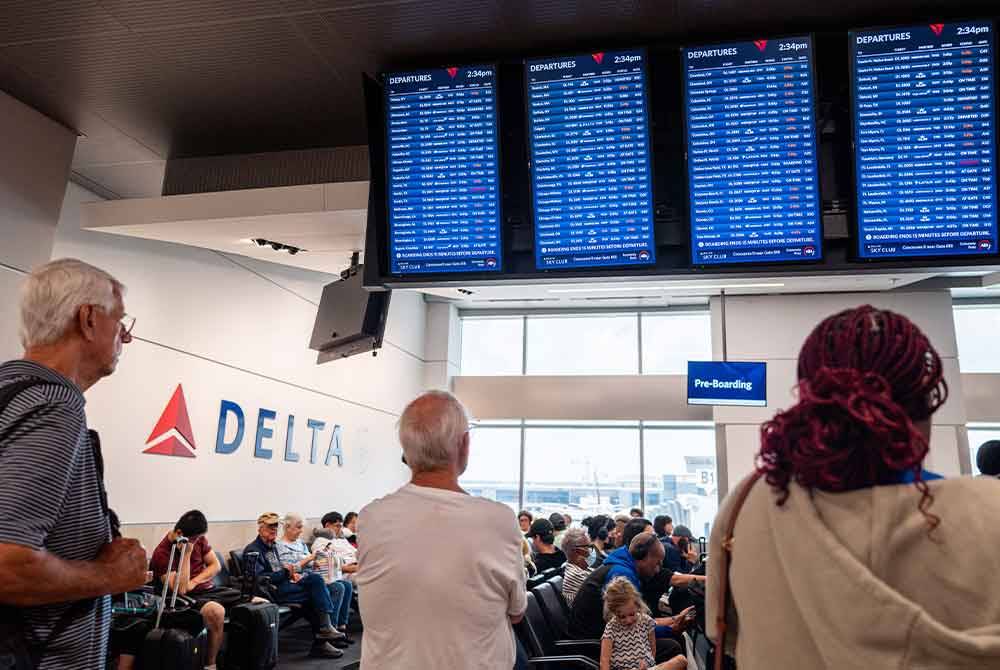 Pelancong melihat jadual penerbangan yang terkesan akibat kemas kini perisian CrowdStrike di Lapangan Terbang Antarabangsa Hartsfield-Jackson Atlanta. - AFP