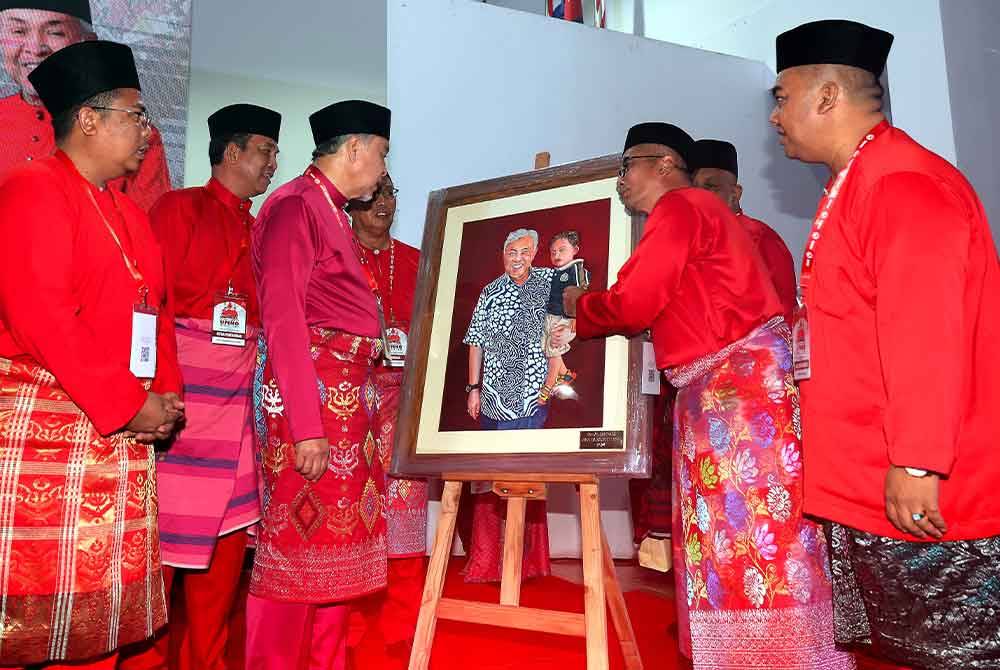 Ahmad Zahid menerima cenderahati daripada Ketua UMNO Bahagian Tebrau, Datuk Abdul Halim Suleiman (dua, kanan) pada Perasmian Mesyuarat Perwakilan UMNO Bahagian Tebrau. Foto Bernama