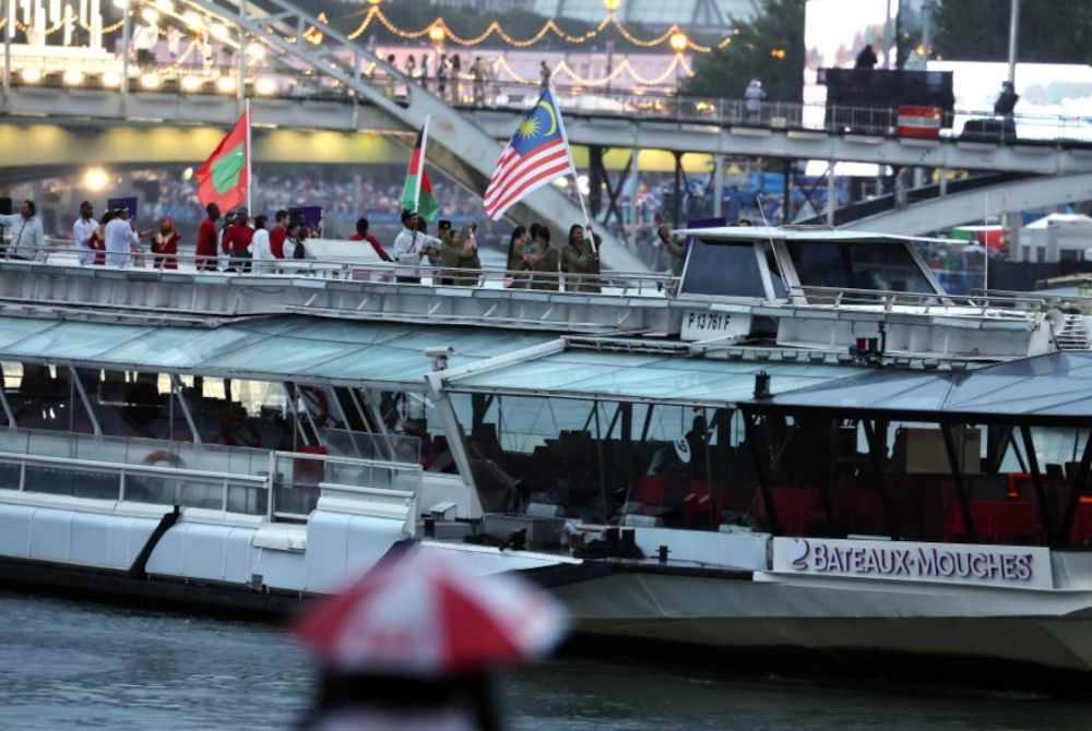 Ketua Kontinjen negara Datuk Hamidin Mohd Amin dan pembawa Jalur Gemilang, atlet terjun, Betrand Rhodic Lises bersama atlet pelayaran negara, Nur Shazrin Mohamad Latif bersama para atlet dan pegawai kontinjen negara menaiki bot pada upacara pembukaan Sukan Olimpik Paris 2024 di Sungai Seine hari ini. Foto Bernama