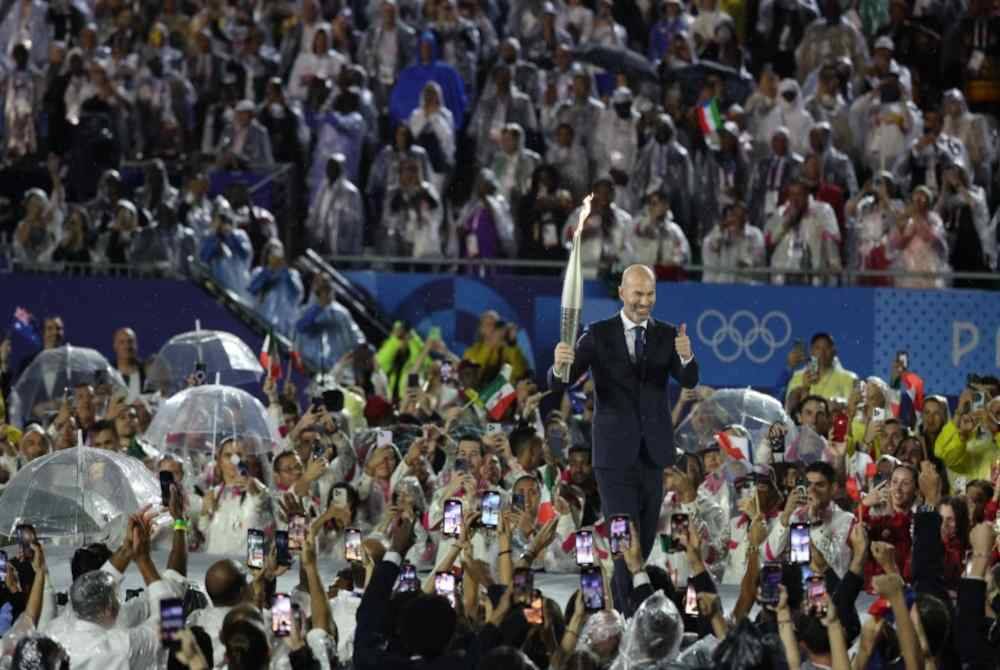 Lagenda bola sepak Perancis Zinadine Zidane membawa Obor Kejohanan pada upacara pembukaan Sukan Olimpik Paris 2024 di Trocadero hari ini. Foto Bernama