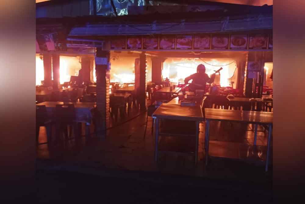 Anggota Bomba dan Penyelamat sedang memadamkan kebakaran di medan selera Taman Lembah Keramat, di sini, pada Sabtu.