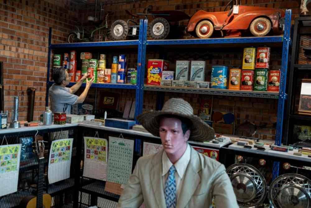 Meng Fai memeriksa dengan teliti koleksi barangan antik yang disimpan rapi di Galeri Ipoh World baru-baru ini. Foto Bernama