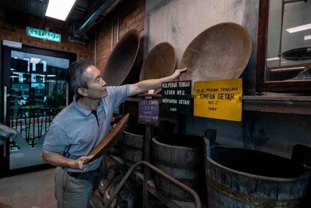 Meng Fai menunjukkan koleksi surat khabar lama yang disimpan rapi. Foto Bernama