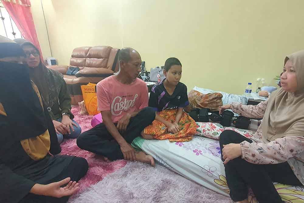 Maznah (kiri) ketika menziarahi Nur Fisya Atira di kediamannya di Taman Sepadu, Tasek Gelugor pada Sabtu.