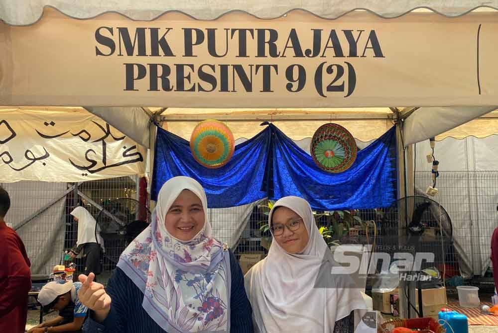 Nurafidah (kiri) bersama Guru Koperasi SMK Putrajaya Presint 9 (2), Nur Qurratu’aini Mohammad Zin di Hari Kantin Sinar Bestari X PTPTN pada Sabtu.