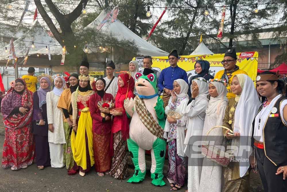 SMK Putrajaya Presint 9 (2) tampil membuat kelainan dengan membawakan maskot katak bagi menarik pengunjung membeli di reruai mereka. Foto SMK Putrajaya Presint 9 (2)