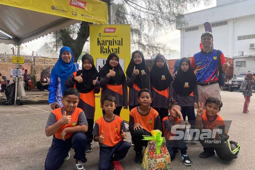 Shamsulfazli (kanan) bersama murid-murid dari SK Kanchong Tengah menyertai lima acara sukan rakyat antaranya susun bata, lari dalam guni dan terompah gajah.