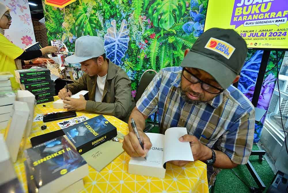 Arman Jazee menandatangani karya 'Sindiket II' sempena pelancarannya pada Sabtu.