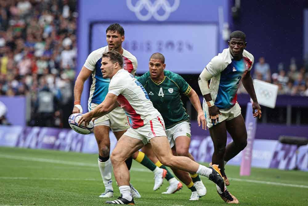 Pemain Perancis Antoine Dupont mengasak pemain Afrika Selatan dalam acara Ragbi 7 sebelah pada Sukan Olimpik Paris 2024 di Stade De France. Foto Bernama
