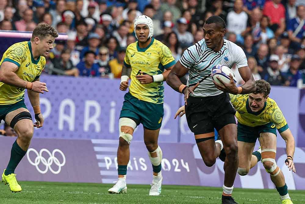 Pemain Fiji Joseva Talacolo ketika mengasak pemain Australia dalam acara Ragbi 7 sebelah pada Sukan Olimpik Paris 2024 di Stade De France. Foto Bernama