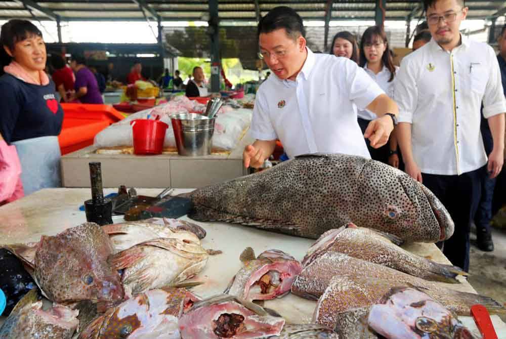 Kor Ming (dua dari kanan) ketika meninjau operasi Pasar Sementara Pasir Pinji pada Ahad.