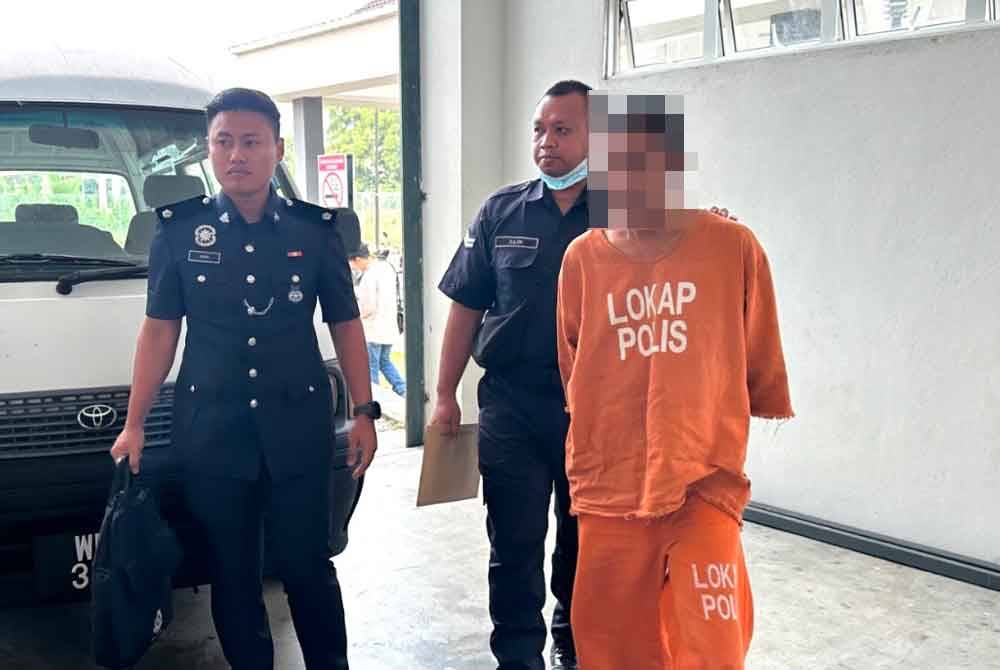 Tertuduh (kanan) dikawal ketat polis ketika tiba di mahkamah untuk didakwa.