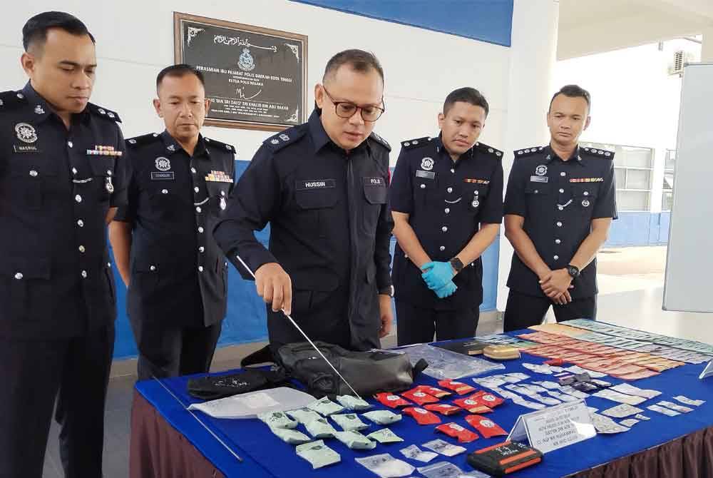 Hussin (hadapan) menunjukkan sebahagian barang rampasan pada sidang media di IPD Kota Tinggi pada Ahad.