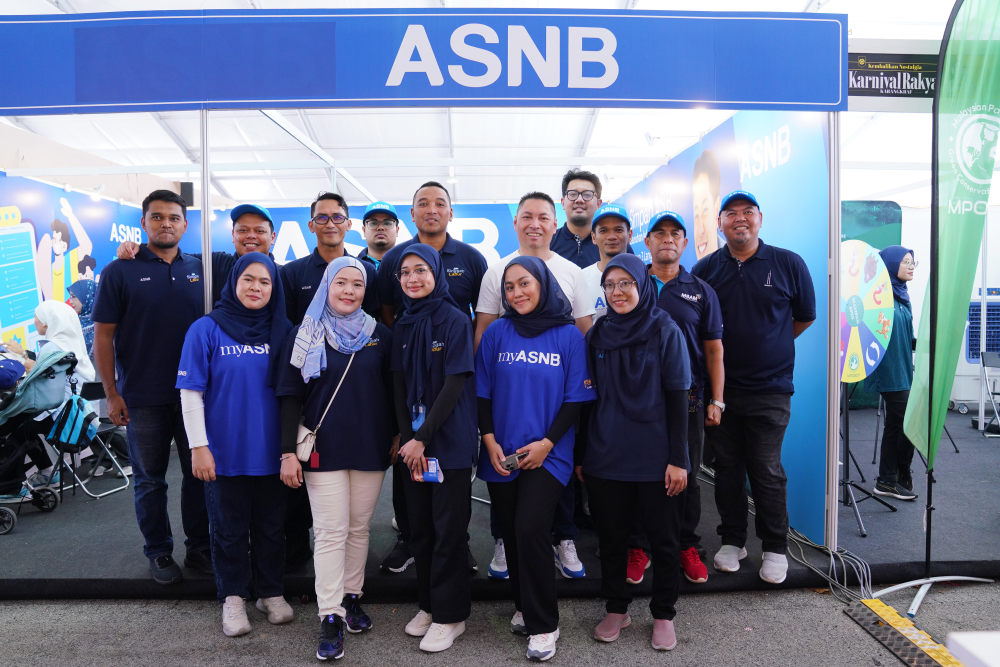 Muzzaffar (empat dari kanan, tengah) bersama pekerja yang bertugas di reruai ASNB sepanjang berlangsungnya Karnival Rakyat Karangkraf 2024.