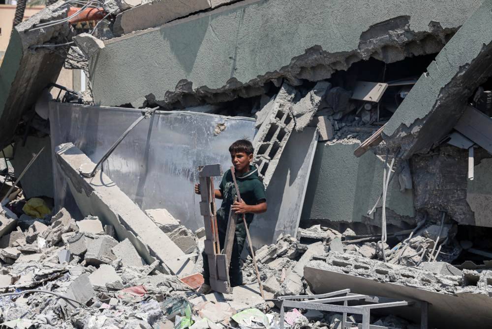 Seorang budak lelaki berdiri di antara runtuhan hospital lapangan yang diserang tentera Israel di Deir al-Balah, tengah Semenanjung Gaza. Foto Xinhua