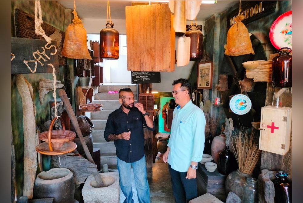 Bau (kanan) melihat barangan antik yang disusun di halaman rumah Mario.