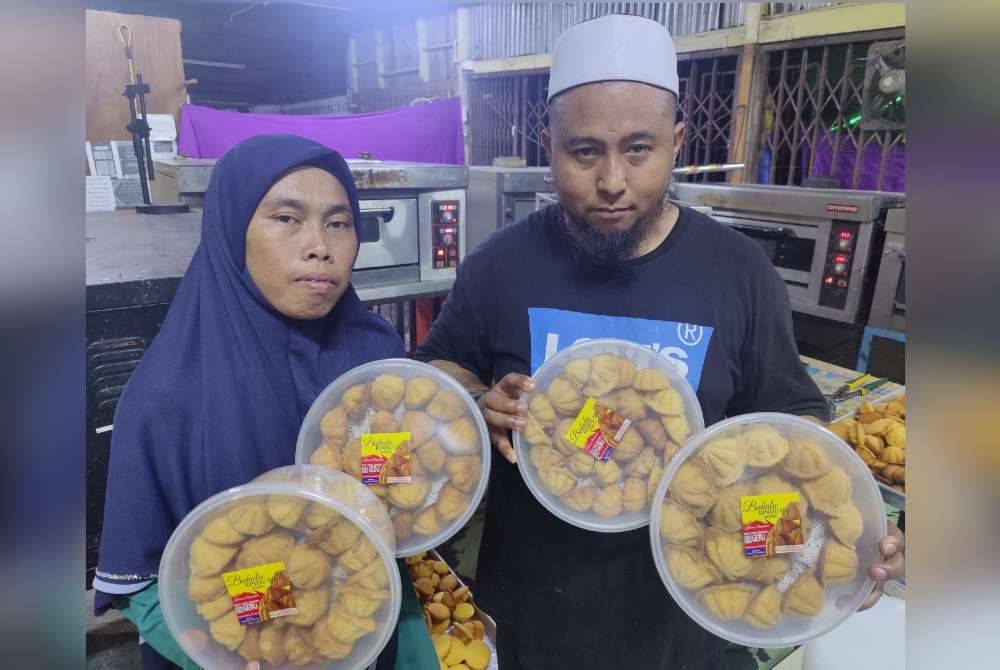 Siti Idayou dan suaminya menunjukkan kuih baulu di dalam bekas yang sedia untuk dijual kepada pelanggan.
