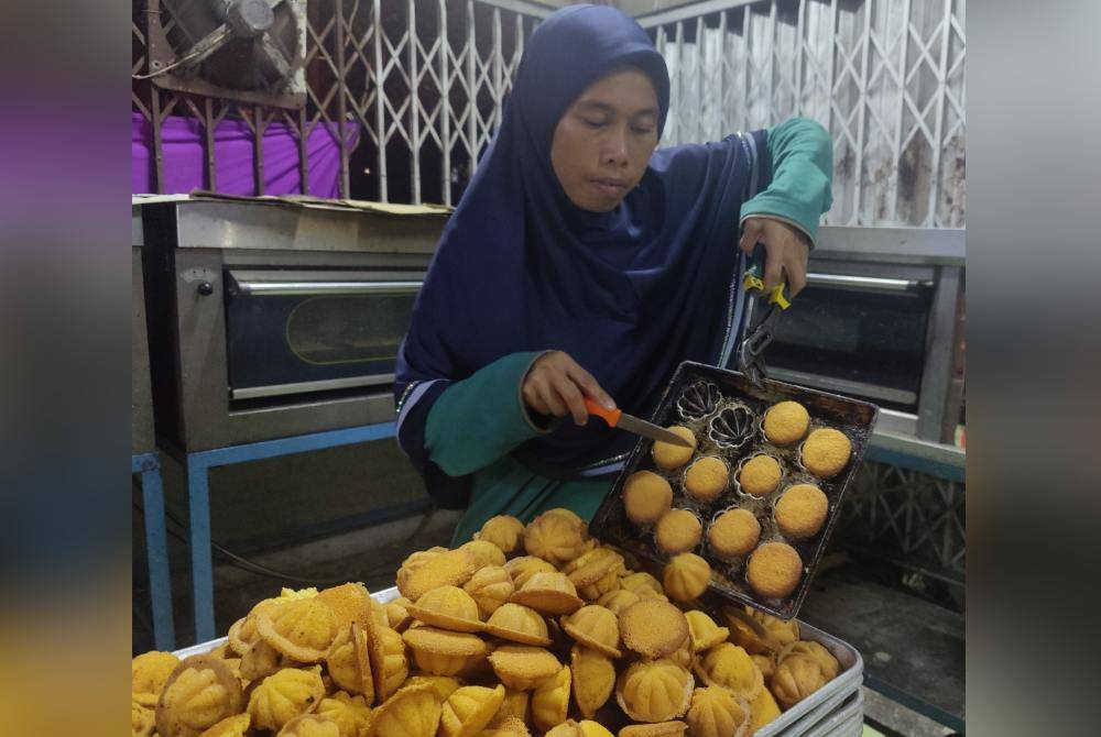 Siti Idayou mengeluarkan baulu yang telah siap dibakar daripada acuan.