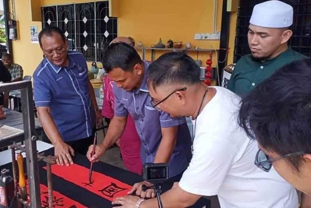 Andansura (kiri) dan Mohamad Ayub (dua dari kiri) mencuba aktiviti disediakan pada siri jelajah PTP di sebuah rumah ibadat di Sungai Klau, Dong, Raub.