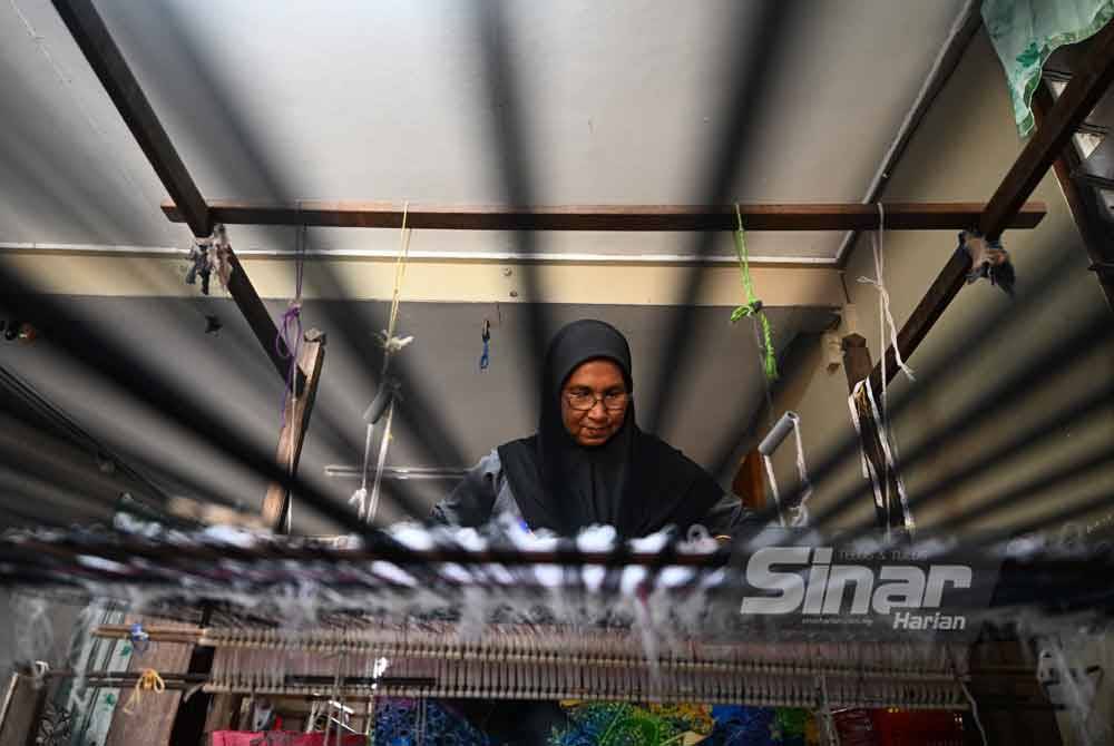 Kak Nah menenun songket di kediamannya di Kampung Raja Baran, Chendering.