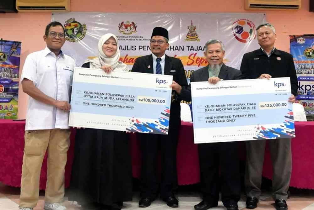 Emran (dua dari kanan) menerima replika cek bernilai RM100,000 dan RM125,000 daripada wakil KPS pada Majlis Penyerahan Tajaan Kejohanan Bola Sepak Piala Raja Muda Selangor dan Piala Datuk Mokhtar Dahari 2024 di Kelab Warga Emas Seksyen 24 Shah Alam.