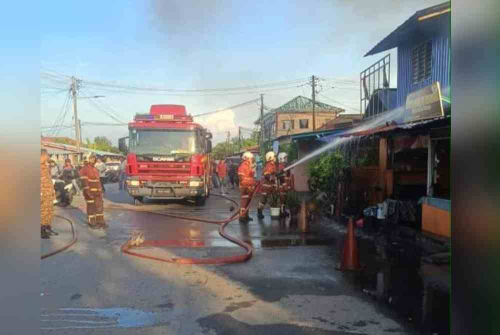 Anggota bomba giat memadam kebakaran melibatkan sebuah rumah dan kedai di Jalan Mat Raji, Padang Jawa, Shah Alam, Selangor pada Selasa. Foto JBPM.