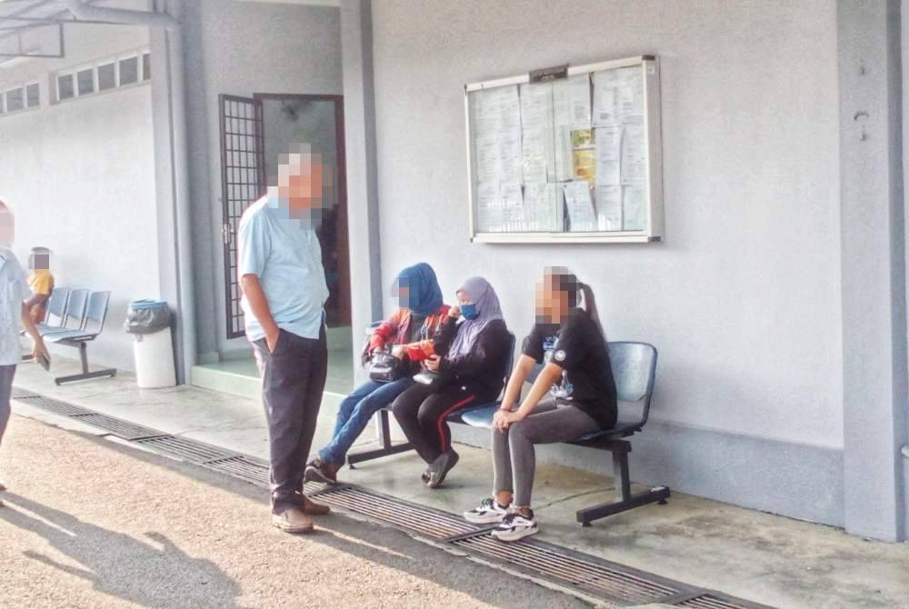 Tertuduh (duduk, tengah) ketika hadir di mahkamah bagi pertuduhan berkenaan.