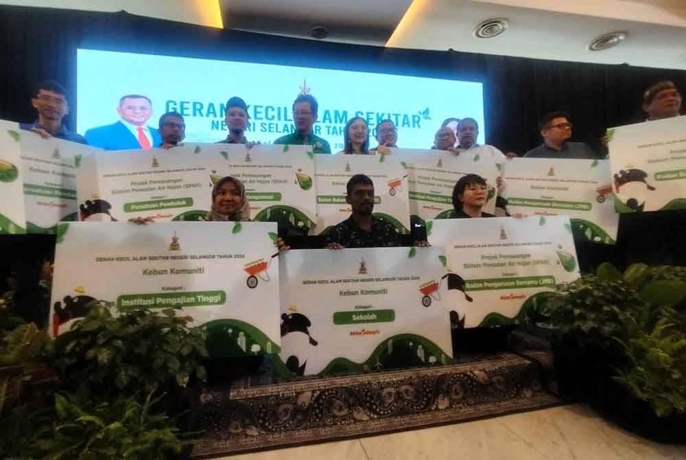 Penerima geran kecil alam sekitar bergambar bersama Jamaliah (berdiri, tengah) selepas menerima geran masing-masing pada Selasa.