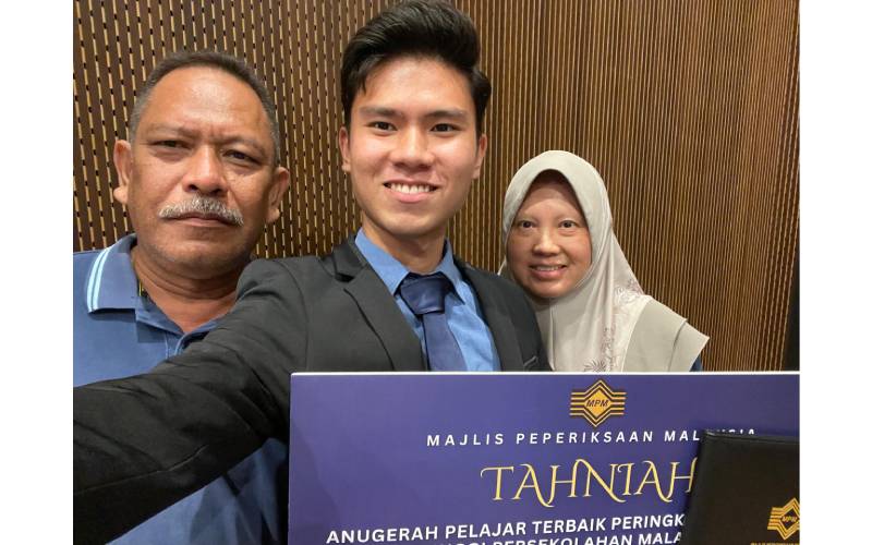 Muhammad Hadiz bersama kedua ibu bapanya.