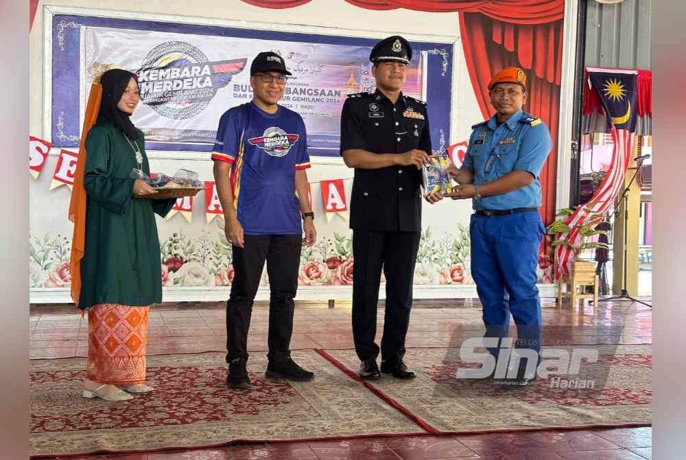 Agihan Jalur Gemilang daripada Mohamad Ismail (dua dari kanan) yang diiringi Muhd Nor Aswadi (dua dari kiri) kepada wakil agensi dari Jabatan Pengangkutan Awam.