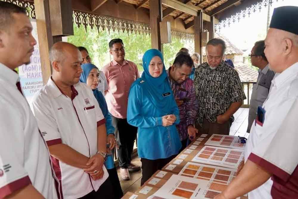 Saiful Bahri (dua dari kiri) bersama Afnida melihat jenis kraf ukiran sempena majlis MoA dan acara pecah tanah Projek Kompleks Industri Ukiran Terengganu di Kampung Raja, Besut.