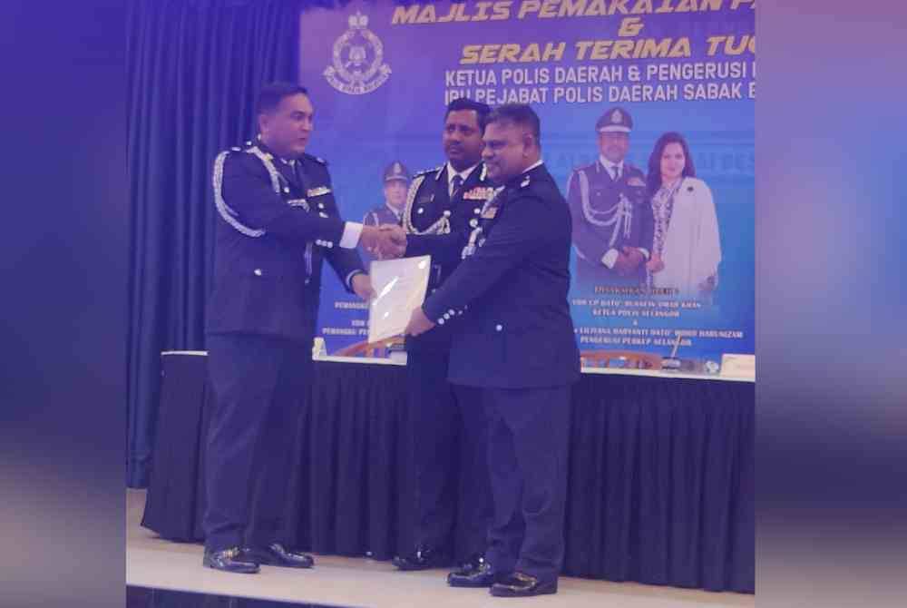 Robin (kanan) dan Khalid (kiri) sambil disaksikan Hussein pada Majlis Serah Terima Tugas di IPD Sabak Bernam pada Khamis.