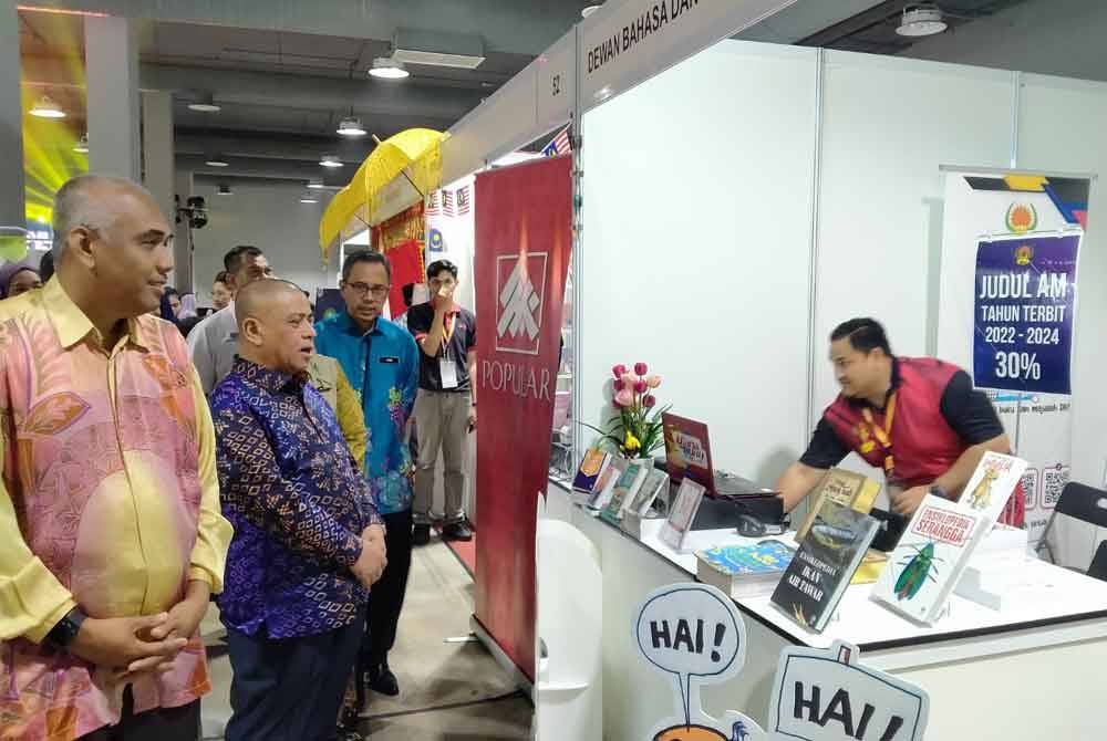 Saarani (dua dari kiri) melawat gerai pameran selepas menyempurnakan perasmian Bazar Buku Perak.