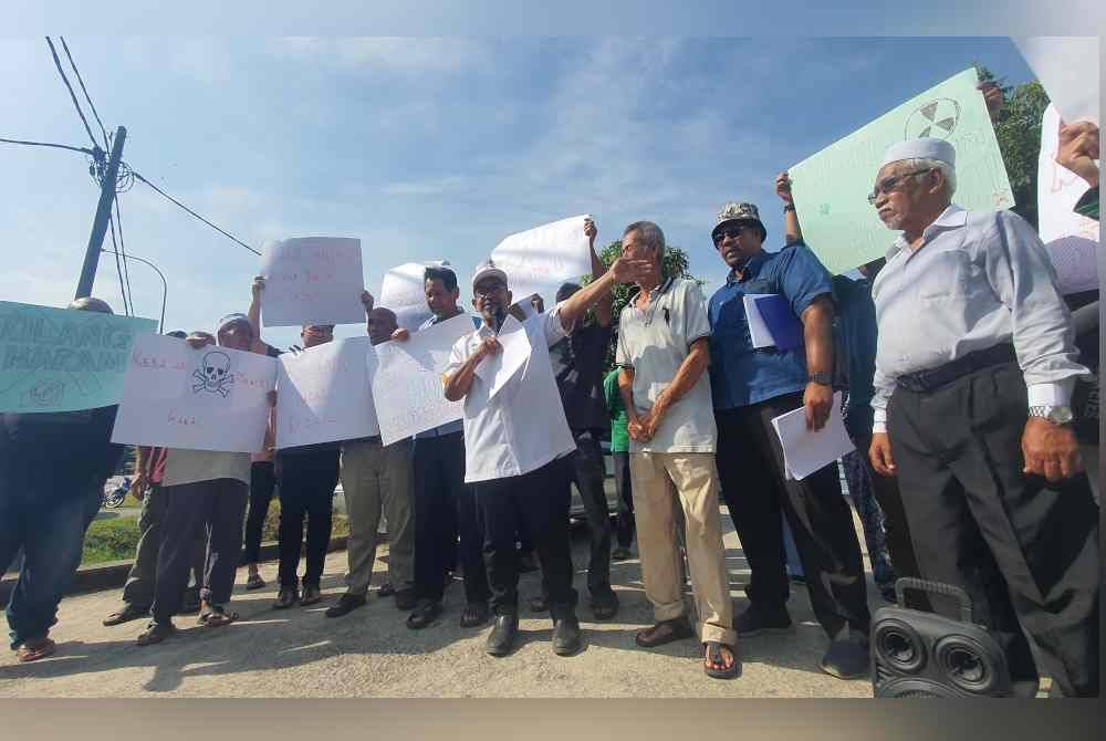 Penduduk mengadakan bantahan aman di hadapan kilang haram di Kampung Permatang Ara, pada Jumaat.