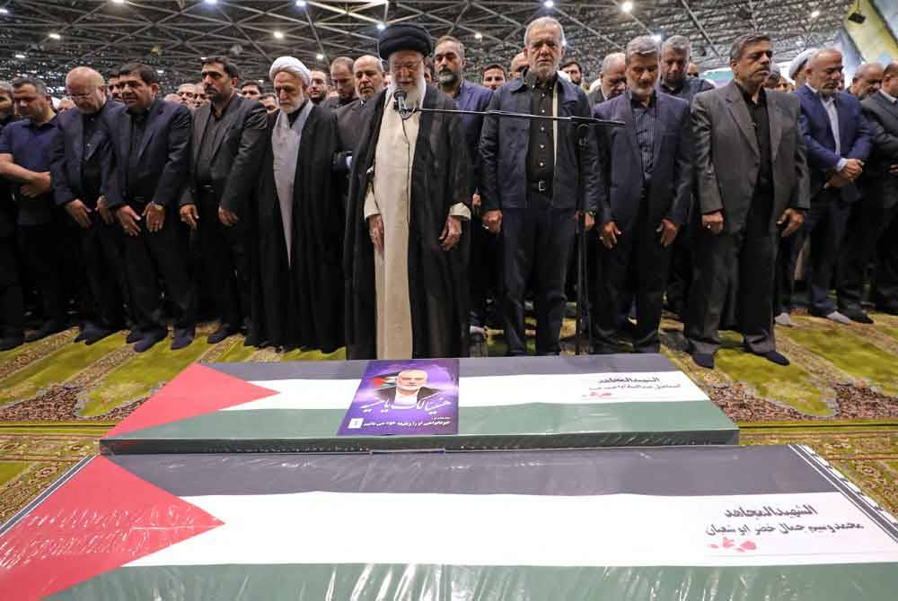 Pemimpin tertinggi Iran, Ayatollah Ali Khamenei (tengah), dengan Presiden Iran, Masoud Pezeshkian, disebelah kirinya, memimpin solat jenazah pemimpin Hamas, Ismail Haniyeh dan pengawal peribadinya di Teheran, Iran.