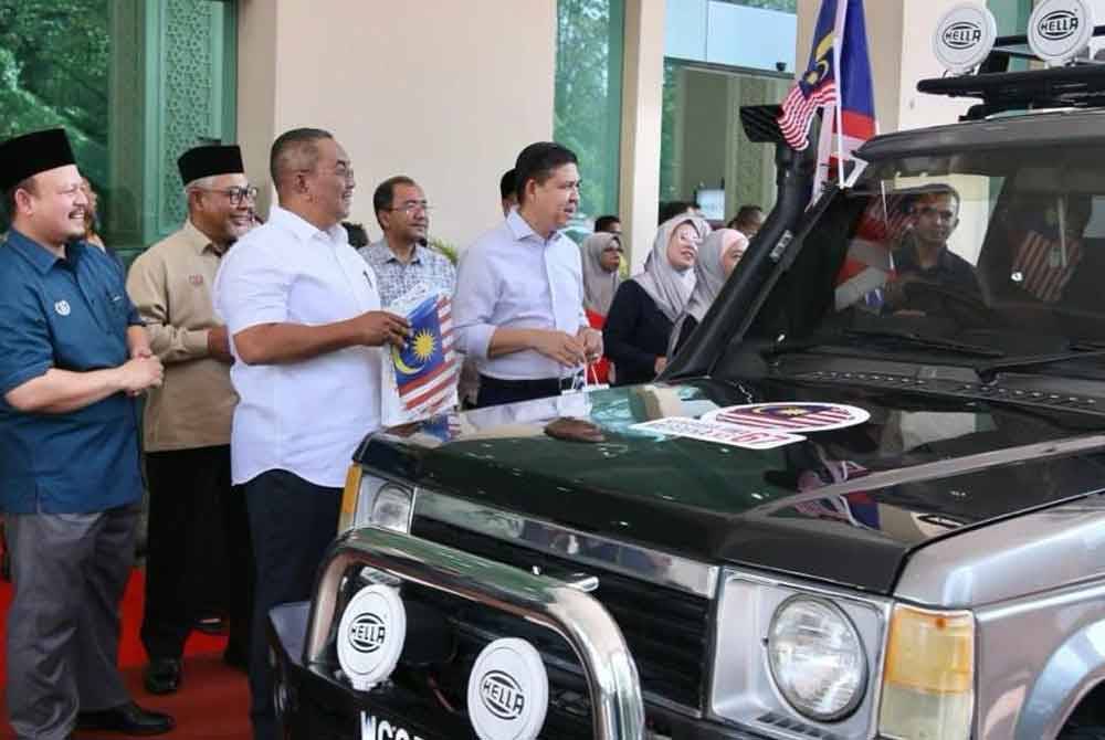 Muhammad Sanusi (dua dari kiri) melepaskan kenderaan konvoi Jiwa Merdeka yang akan menjelajah ke 12 daerah di negeri ini.