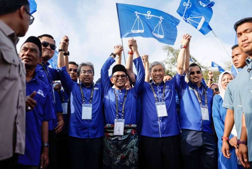 Calon Barisan Nasional, Mohd Azmawi Fikri Abdul Ghani (tengah) bersama Pengerusi Barisan Nasional, Datuk Seri Dr Ahmad Zahid Hamidi ketika tiba di Pusat Penamaan Calon bagi Pilihan Raya Kecil (PRK) Dewan Undangan Negeri (DUN) Nenggiri yang bertempat di Dewan Perdana Kompleks Perdana Majlis Daerah Gua Musang pada Sabtu. Foto Bernama
