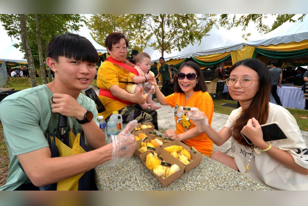 Orang ramai tidak melepaskan peluang makan durian percuma.