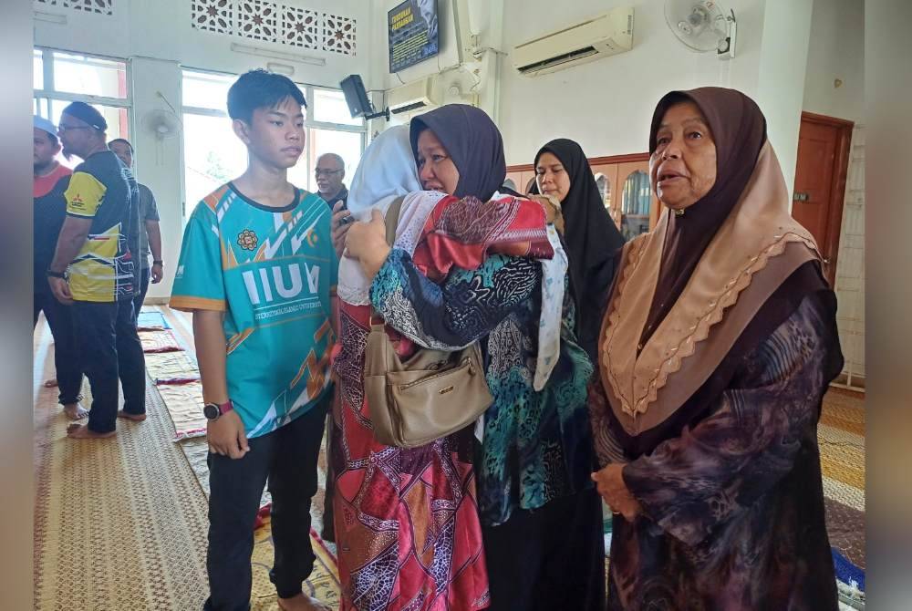 Norrulaini (tengah) ditenangkan oleh waris yang datang melawat jenazah Nurnazatul Fasiha di Masjid An Nur Ketapang Hilir di sini pada Sabtu.