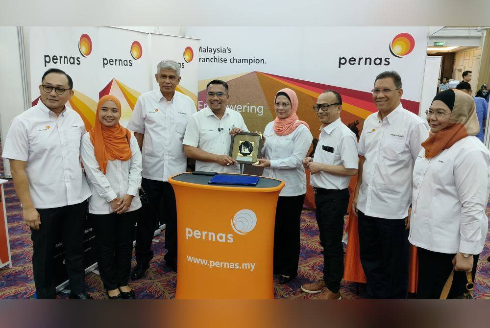 Hazimah (empat dari kiri) menyampaikan cenderamata kepada Amizar ketika lawatan di reruai pameran Pernas sempena Majlis Perasmian Program BizFrancais Pahang 2024 di Dewan Jubli Perak Sultan Ahmad Shah di sini pada Sabtu