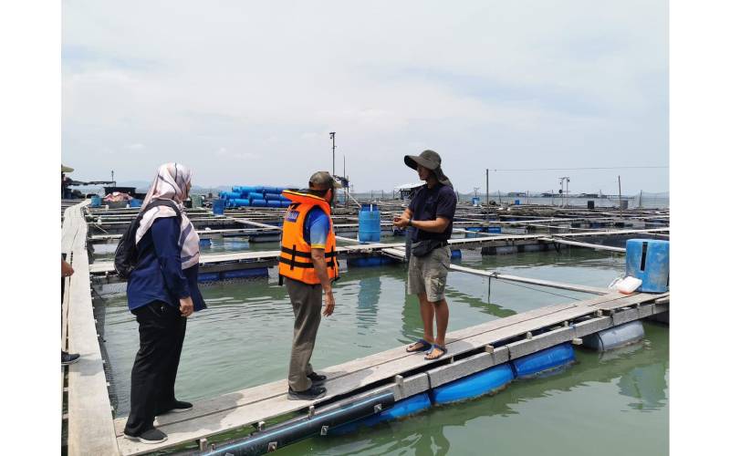 Mohd Uzir (tengah) sedang diberi penerangan mengenai sangkar ikan oleh pemilik di Pulau Jerejak.