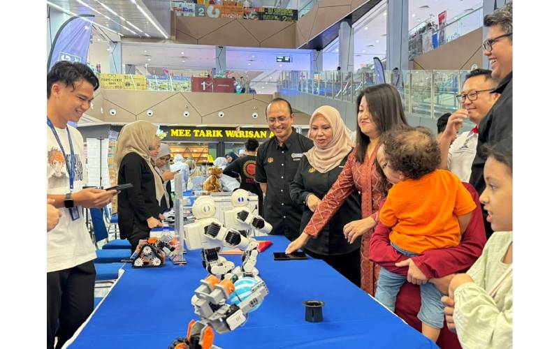 Siew Khim(tiga dari kanan), Norliza dan Ahmad Dasuki melawat reruai pameran robotik dan AI selepas Majlis Perasmian Anak Emas.
