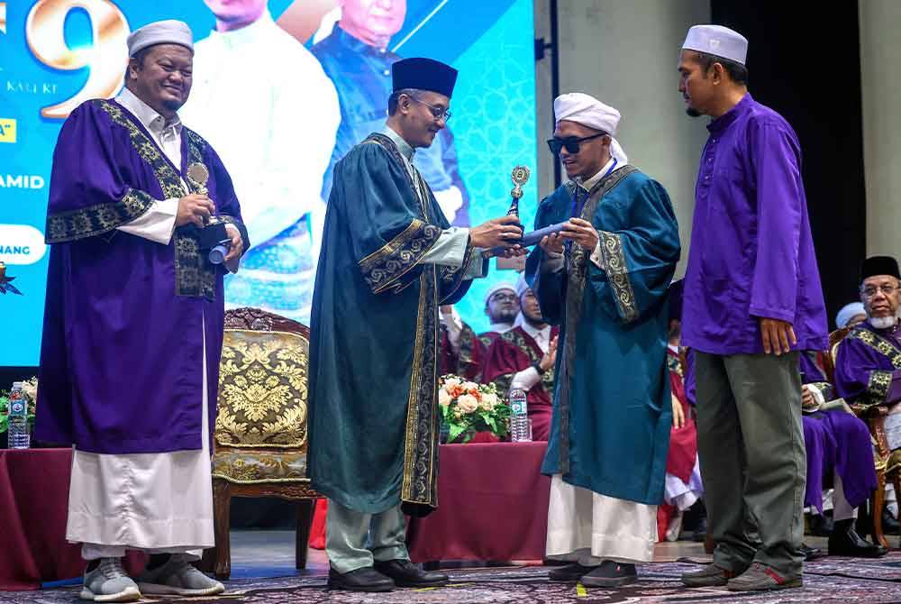 Mohammad menyampaikan sijil konvokesyen kepada graduan cacat penglihatan Amzar Haziq pada Majlis Konvokesyen Huffaz Nusantara kali ke-9 di Dewan Millenium pada Ahad. Foto Bernama