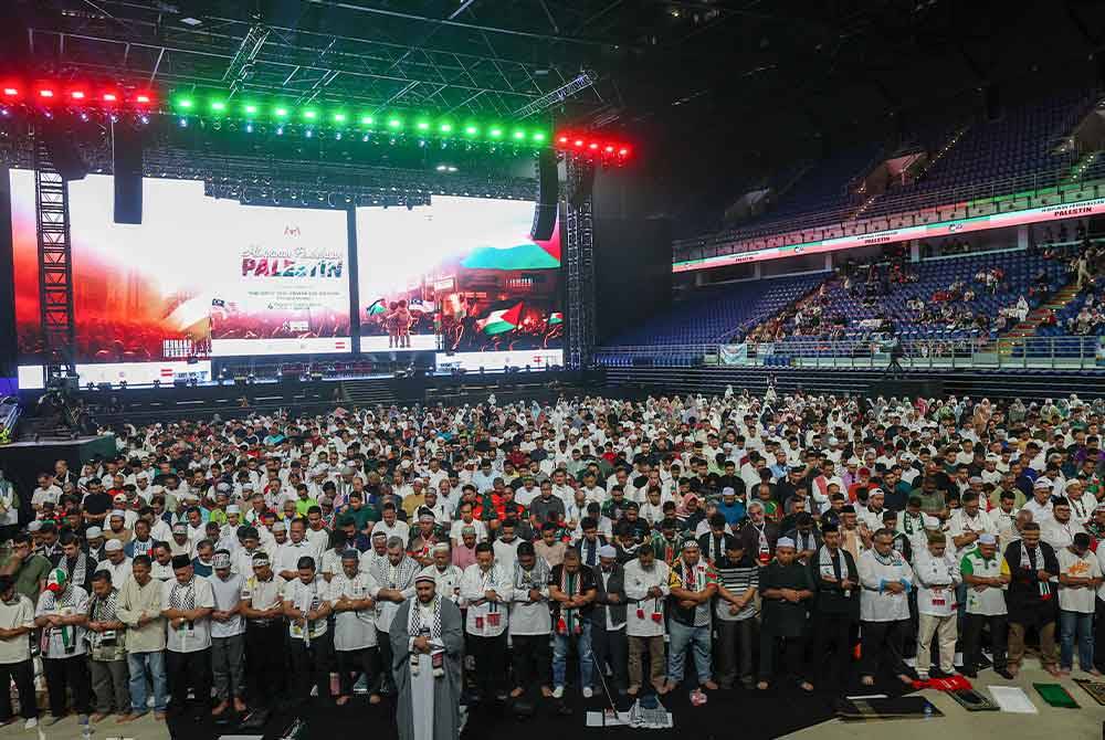 Peserta perhimpunan menunaikan solat Maghrib secara berjemaah dan diketuai imam dari negara Palestin pada Himpunan Pembebasan Palestin di Axiata Arena. Foto Bernama