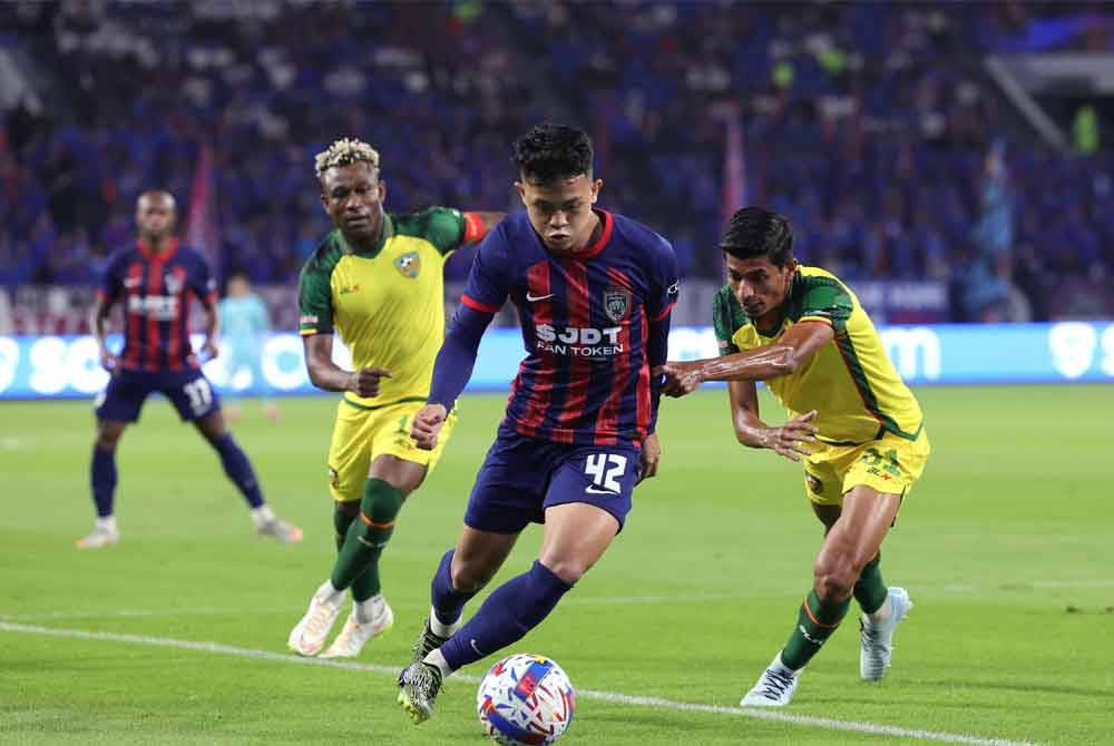 Pemain JDT, Arif Aiman Mohd Hanapi (tengah) diasak oleh pemain Kedah Darul Aman FC, Abdul Halim Saari (kanan) pada perlawanan separuh akhir kedua Piala FA di Stadium Sultan Ibrahim hari ini. Foto Bernama