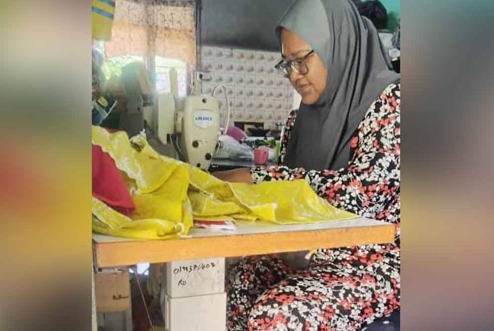 Rodziah menjahit pakaian yang ditempah oleh pelanggan.